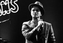 Bruno Mars Is Half Puerto Rican, Half Filipino — And That’s the Whole Sound Female singer in a hat performing on stage with microphone in hand.